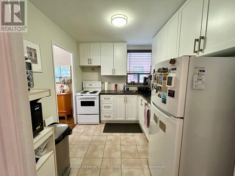 A kitchen with white appliances and cabinets.