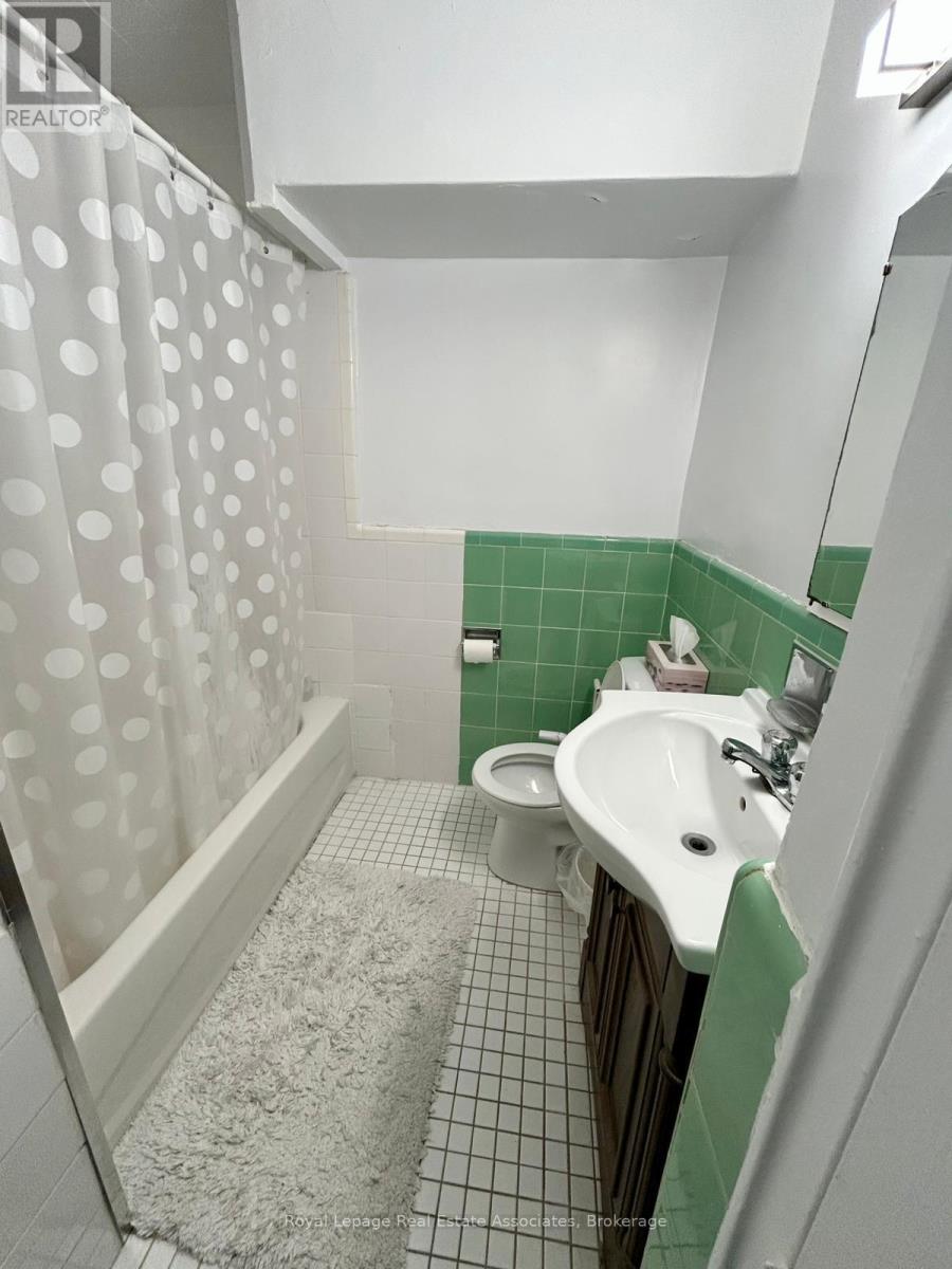 A white sink in a green tiled bathroom.