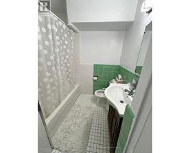 A white sink in a green tiled bathroom.