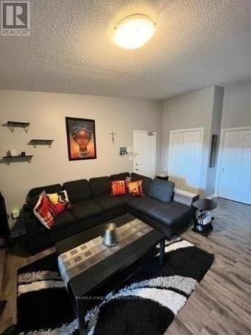 A black couch with a red and white pillow is in the living room.