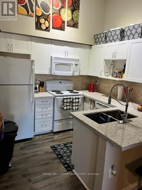 A kitchen with white cabinets and a granite counter top.