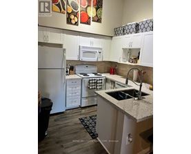A kitchen with white cabinets and a granite counter top.
