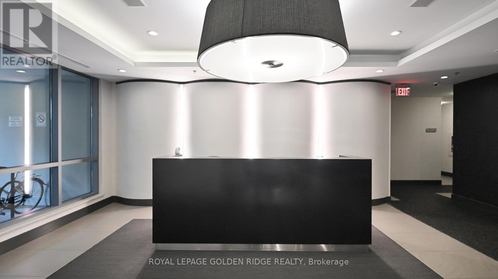A black reception desk in a white hallway with a sign that says "REALTOR".