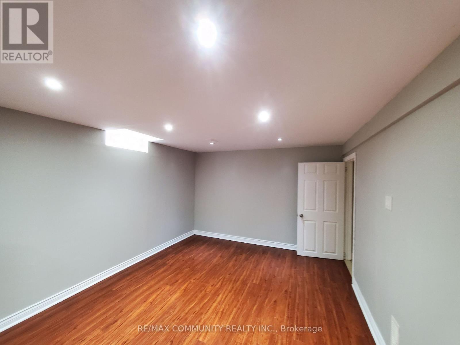A room with wooden flooring and a white door.