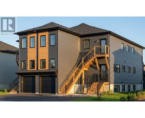A modern house with a garage and a staircase leading to the second floor.