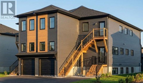 A modern house with a garage and a staircase leading to the second floor.