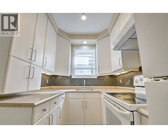A kitchen with white cabinets and appliances.