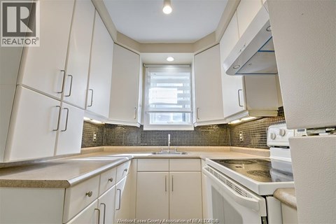 A kitchen with white cabinets and appliances.