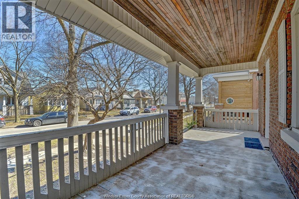 A porch with a wooden ceiling and a brick pillar.
