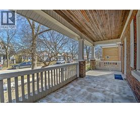 A porch with a wooden ceiling and a brick pillar.