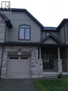 A house with a grey garage door and a black roof.