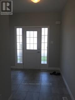 A realtor's photo of a room with a white door and windows.