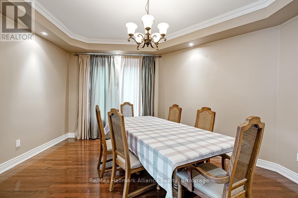 A dining room with a checkered tablecloth and wooden chairs.