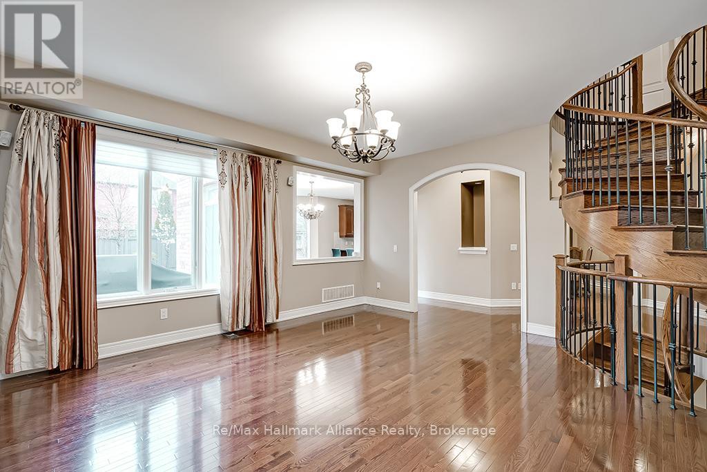A spacious room with a wooden floor and a spiral staircase.
