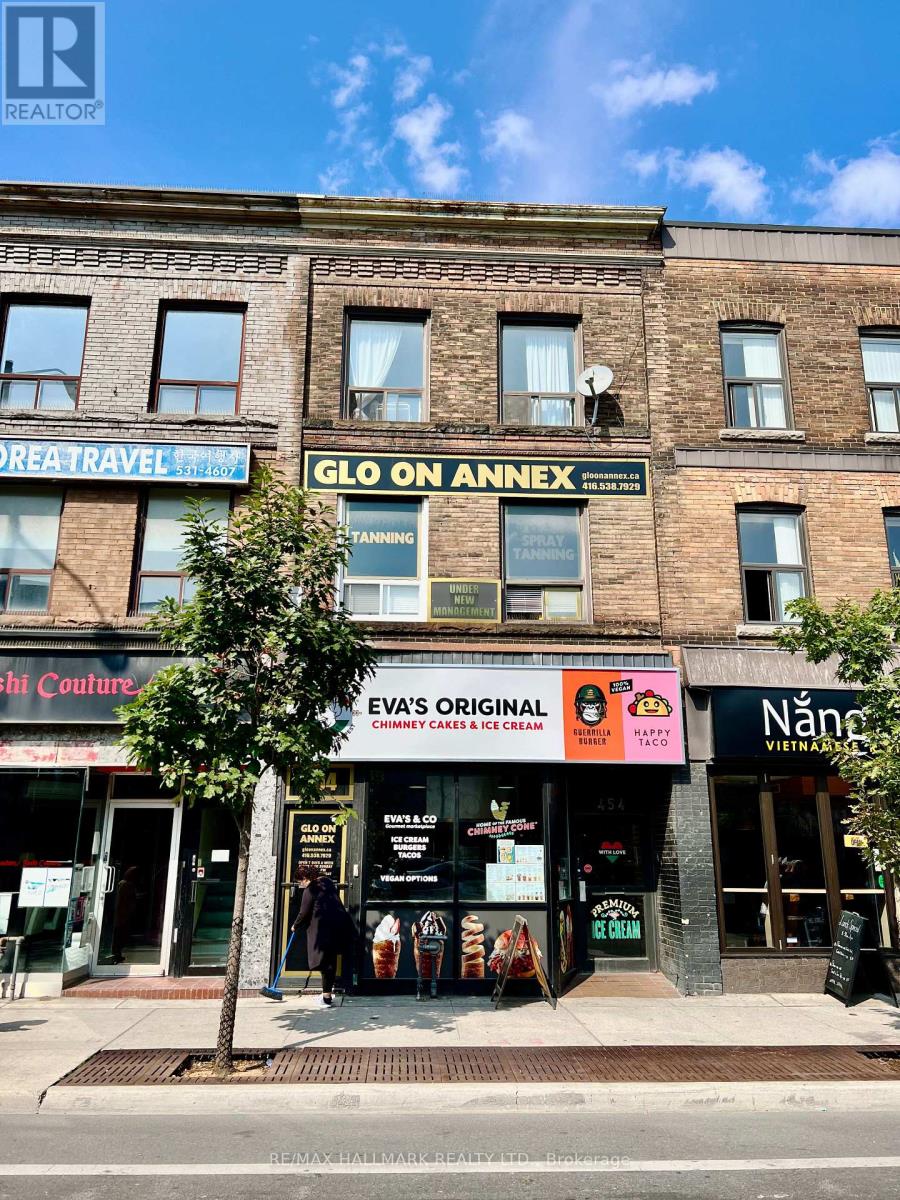 A street view of a building with multiple businesses on the ground floor.