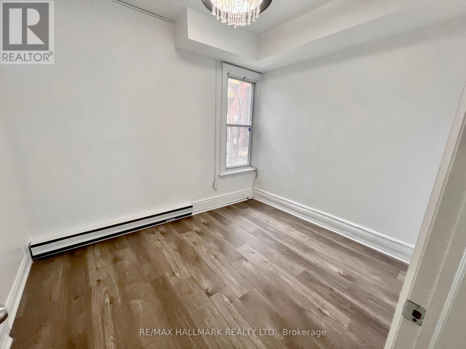 A room with a window and wooden flooring.