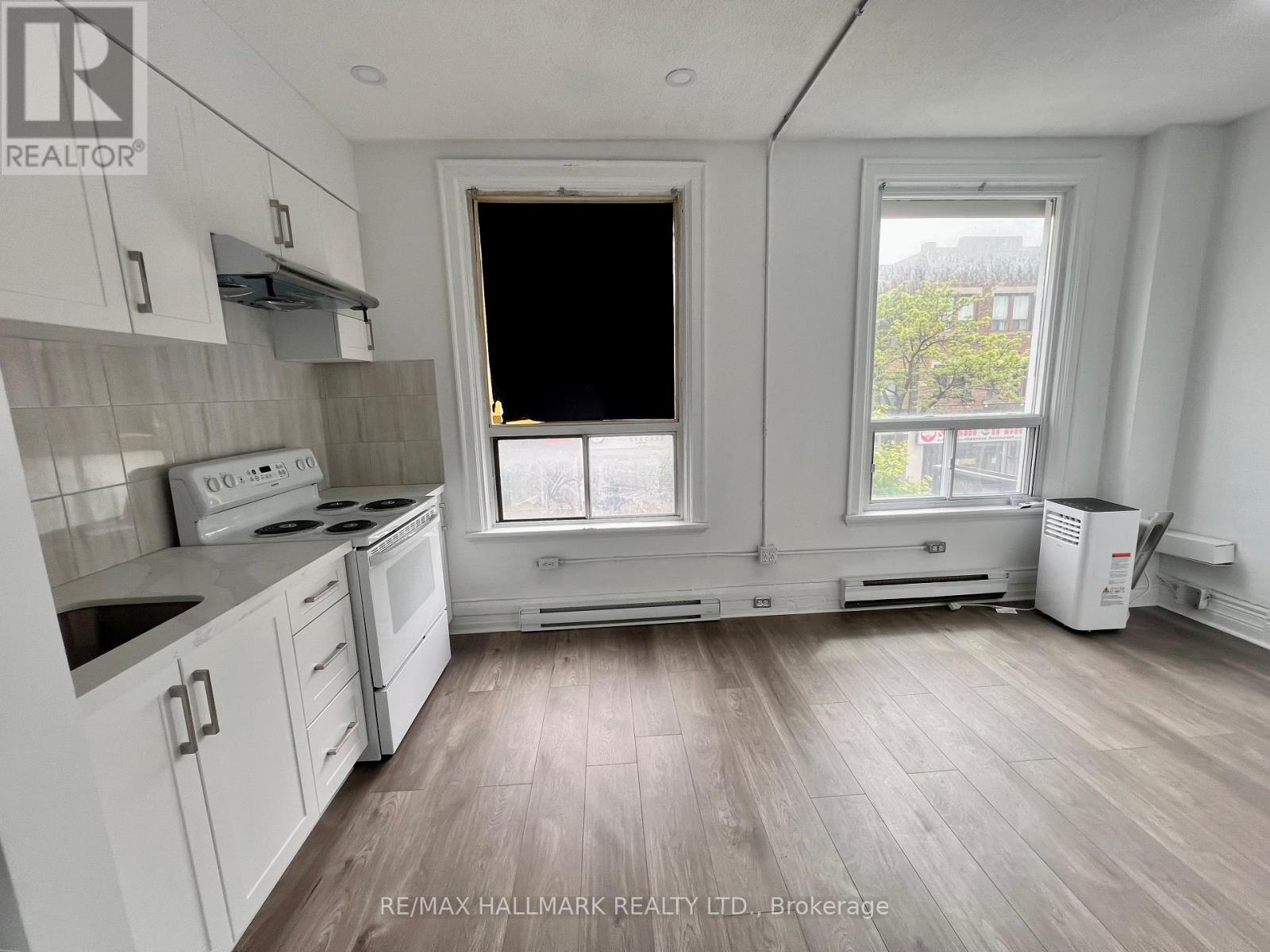 A kitchen with white cabinets and a window.