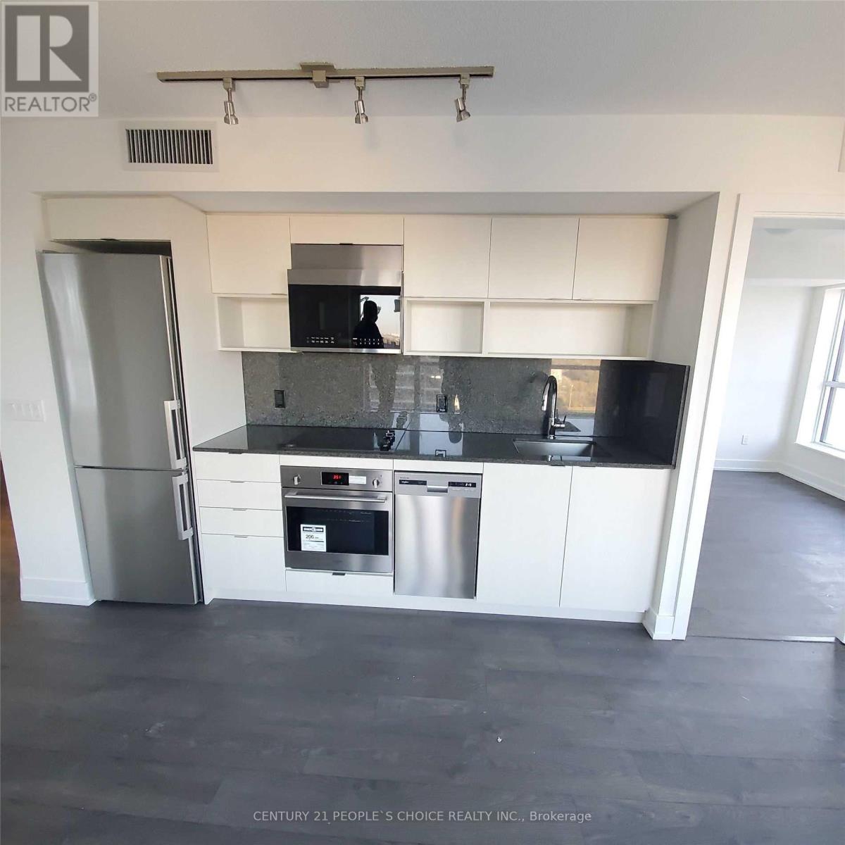 A modern kitchen with white cabinets and stainless steel appliances.