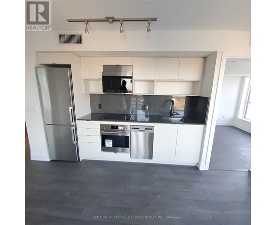 A modern kitchen with white cabinets and stainless steel appliances.