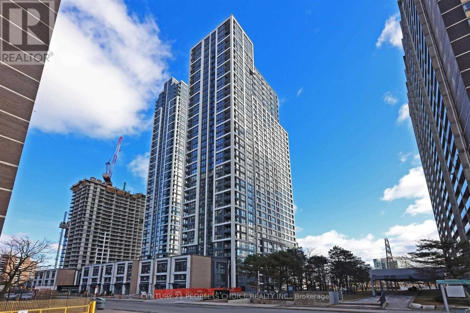A tall building under construction with a crane in the background.