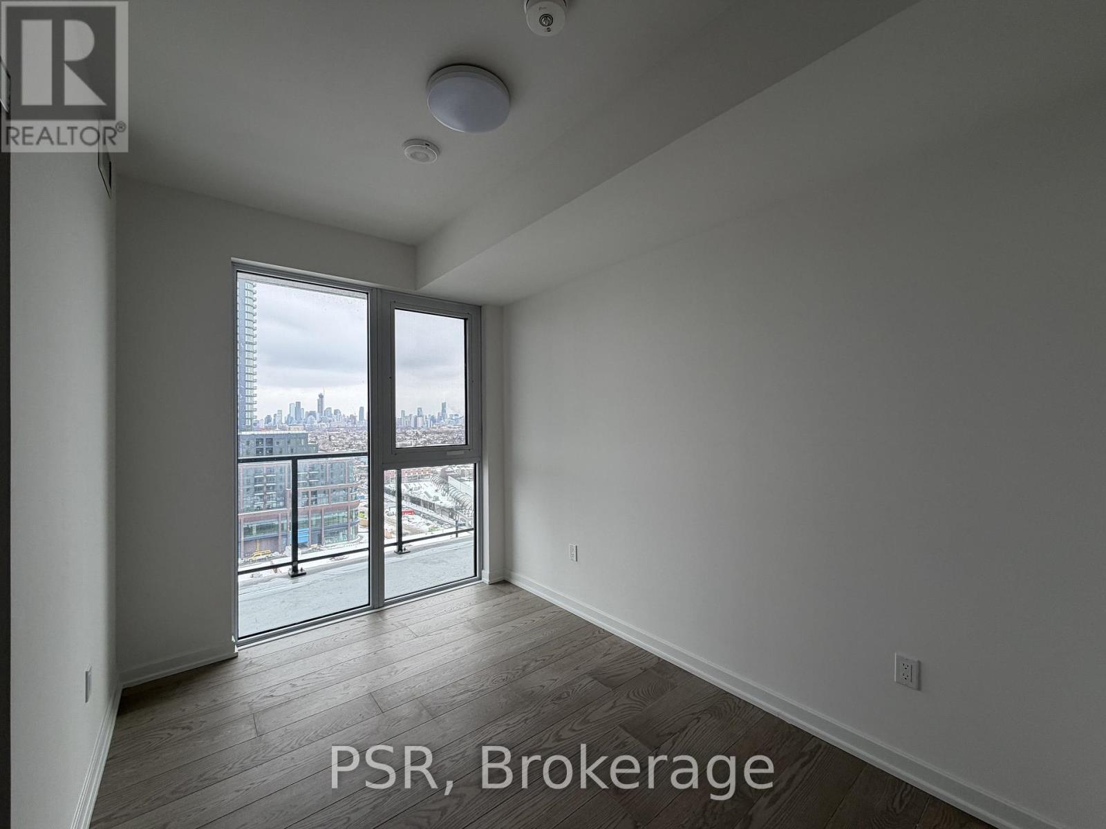 A room with a view of the city through a large window.