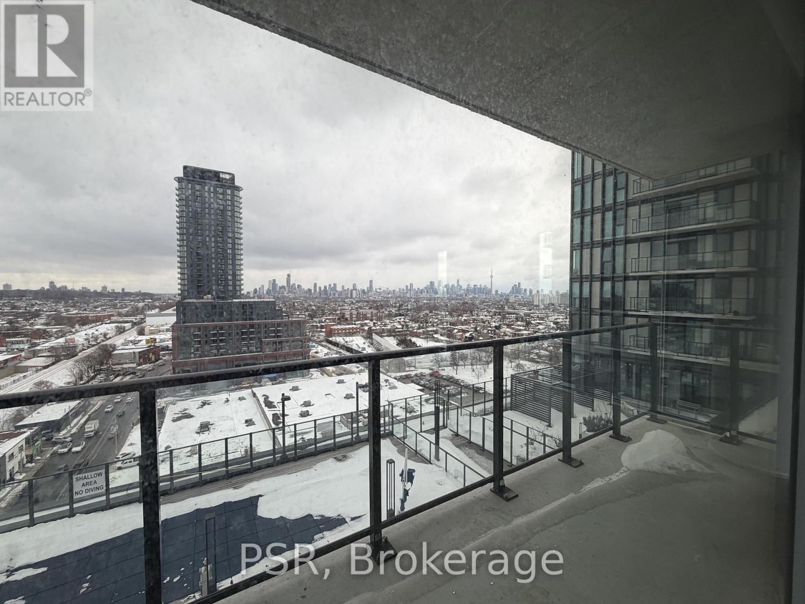 A view from a balcony overlooking a cityscape with a tall building in the distance.