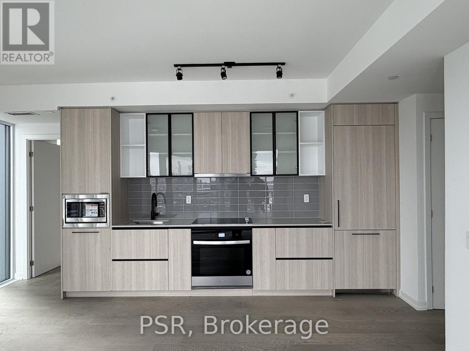 A modern kitchen with wooden cabinets and stainless steel appliances.