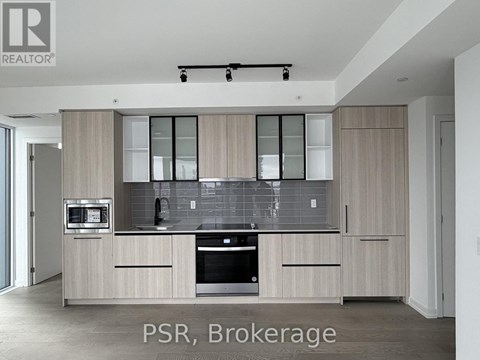 A modern kitchen with wooden cabinets and stainless steel appliances.