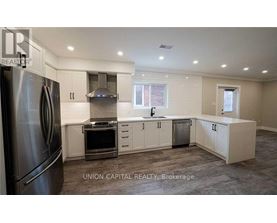 A kitchen with a refrigerator, oven, and cabinets.