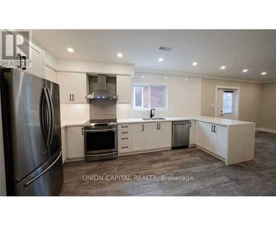 A kitchen with a refrigerator, oven, and cabinets.