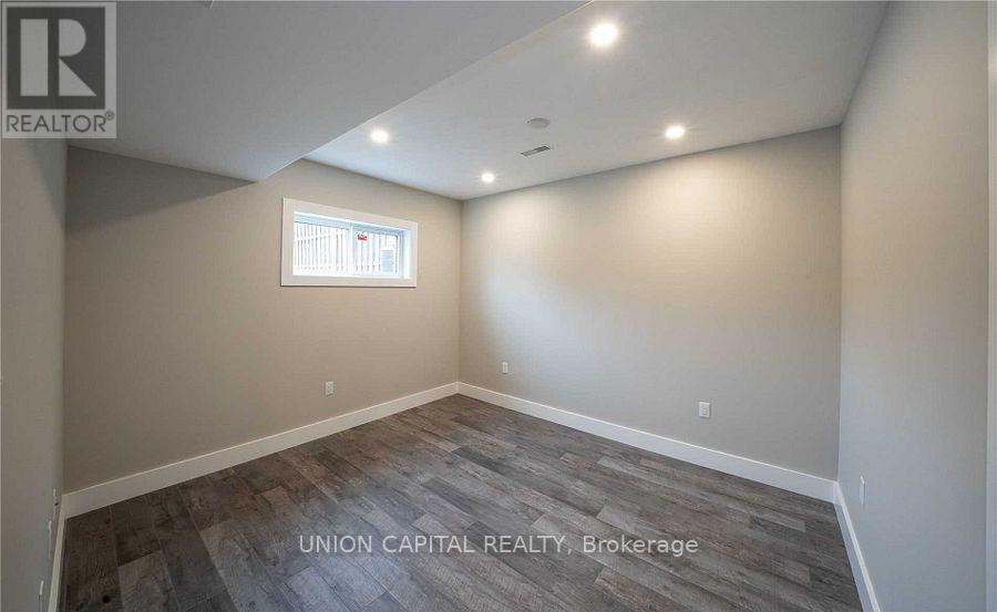 A room with a window and wooden flooring.