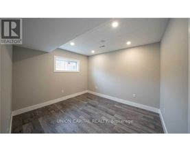 A room with a window and wooden flooring.