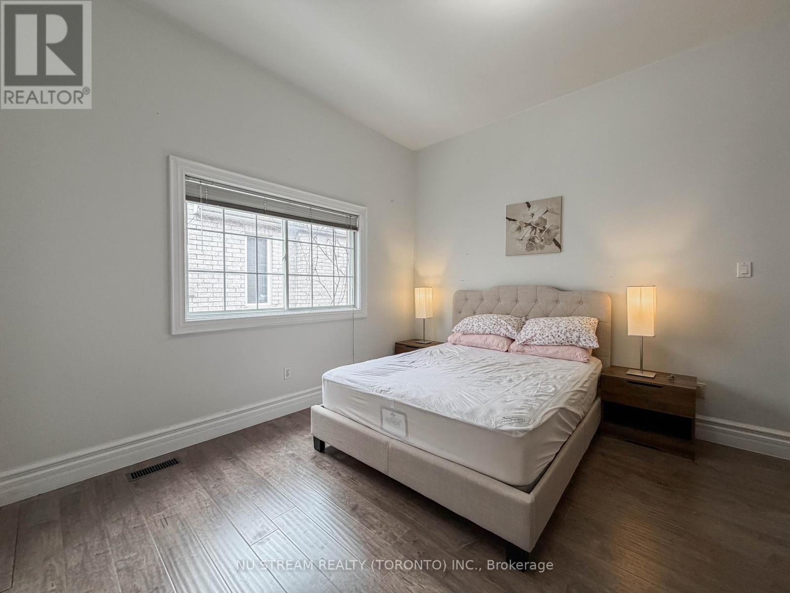 A bedroom with a large bed and a window.