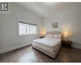 A bedroom with a large bed and a window.