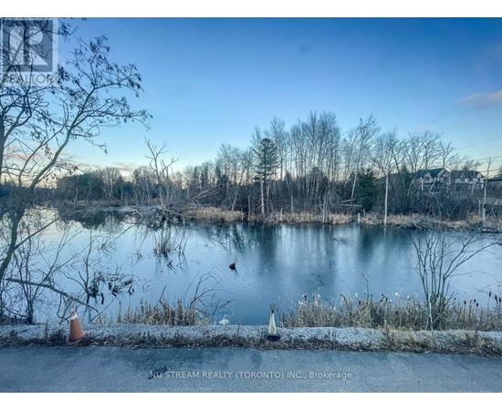 A serene lake surrounded by trees and a clear sky.