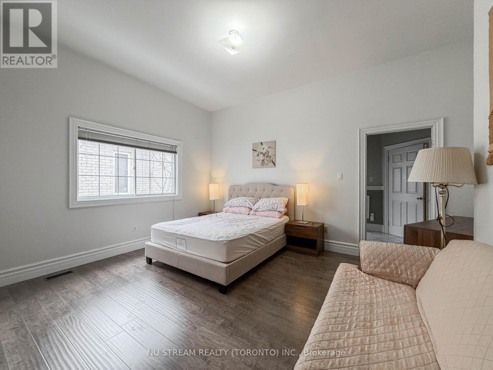 A bedroom with a large bed and a window.