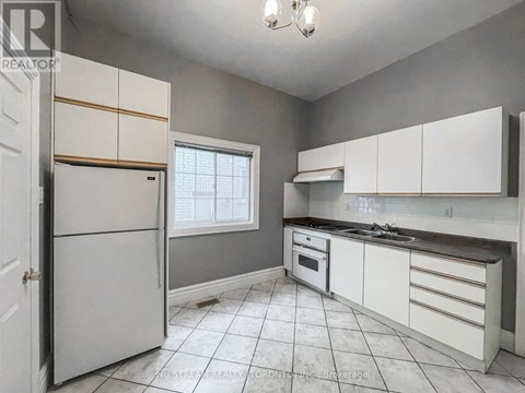 A kitchen with white cabinets and a white refrigerator.