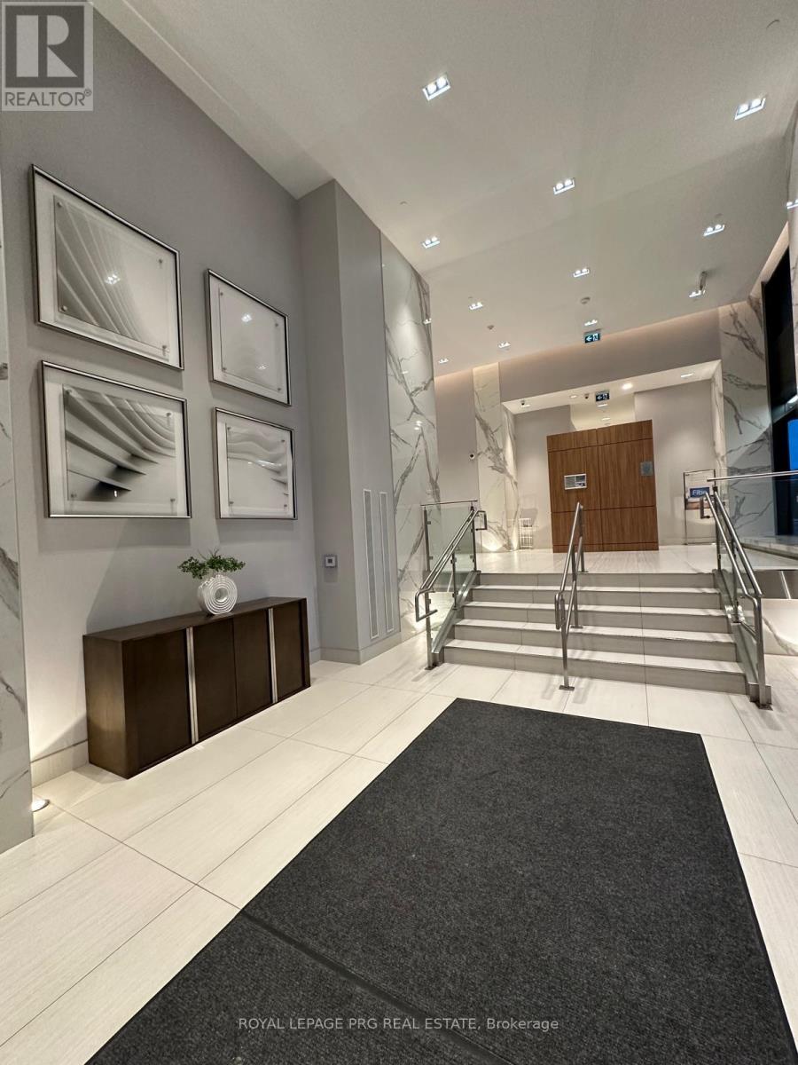 A hallway with a black carpet and white walls.