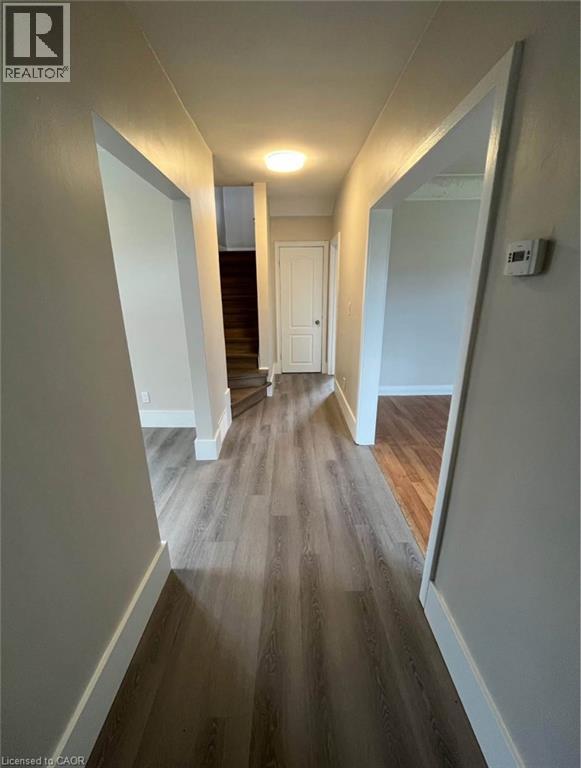 A hallway with wood flooring and white walls.