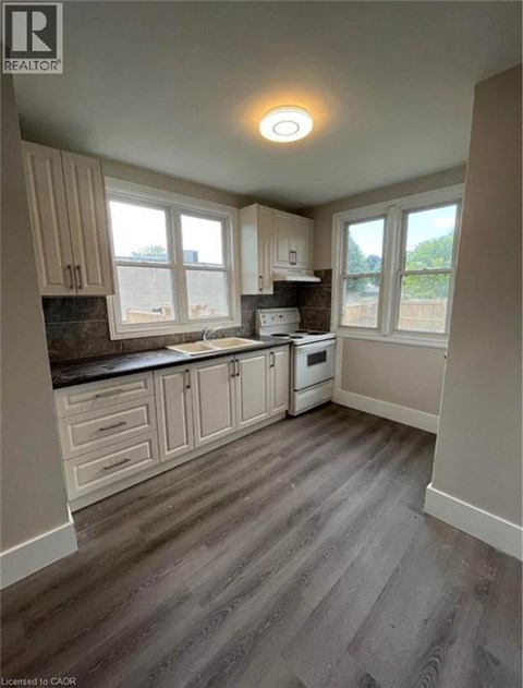 A kitchen with wooden floors and white cabinets.