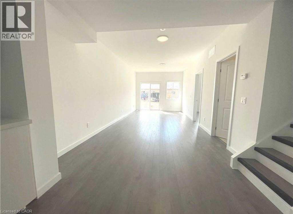 A spacious hallway with wooden floors and white walls.