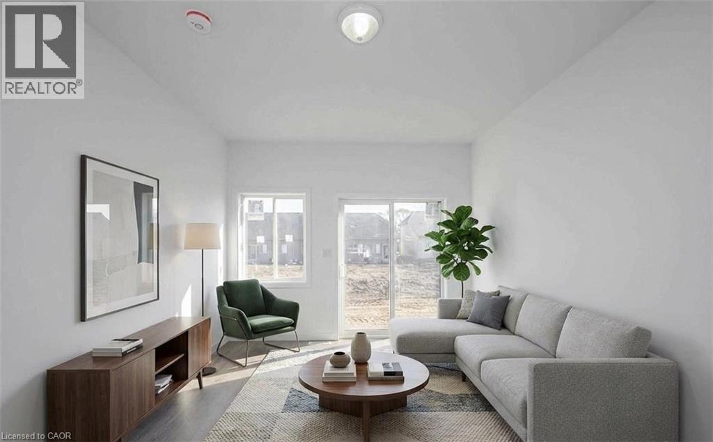 A living room with a grey couch, a green chair, a wooden side table, and a large window.