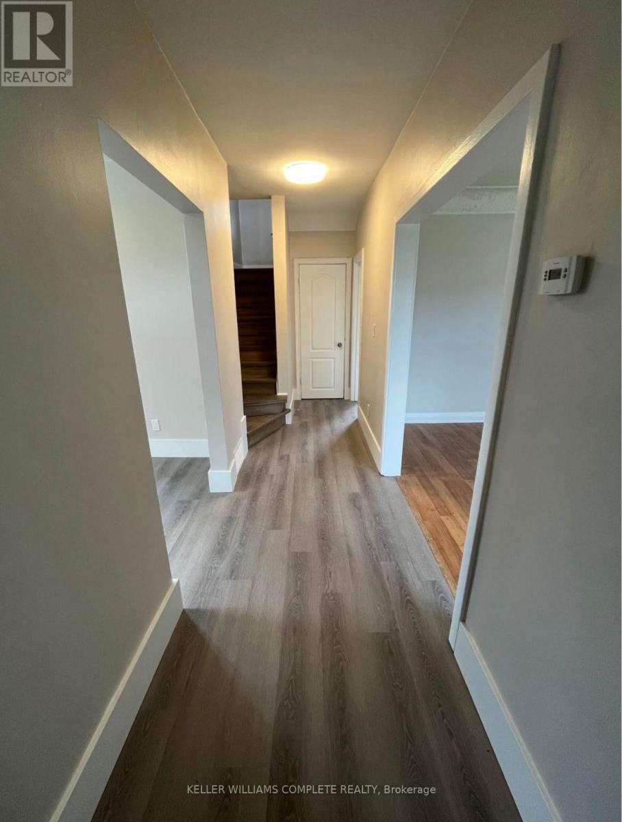 A hallway with wood flooring and white walls.
