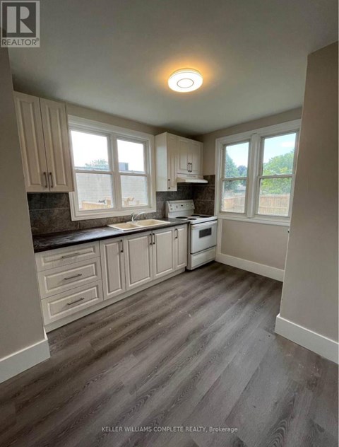 A kitchen with a stove top oven and a window.
