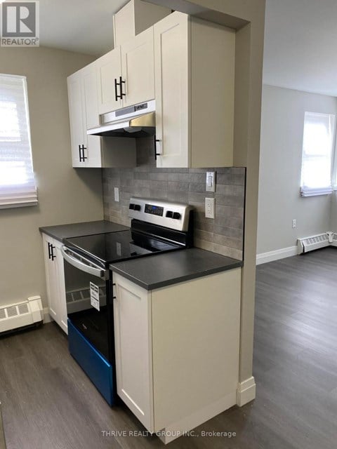 A kitchen with a black countertop and white cabinets.