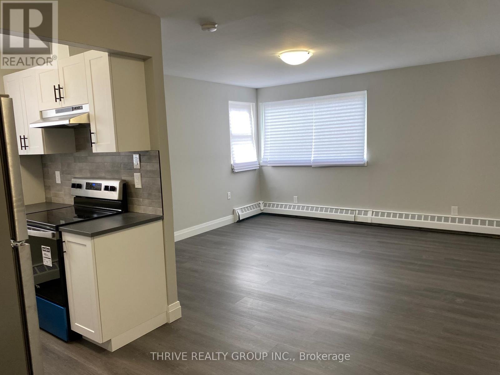 A room with a kitchenette and a window.