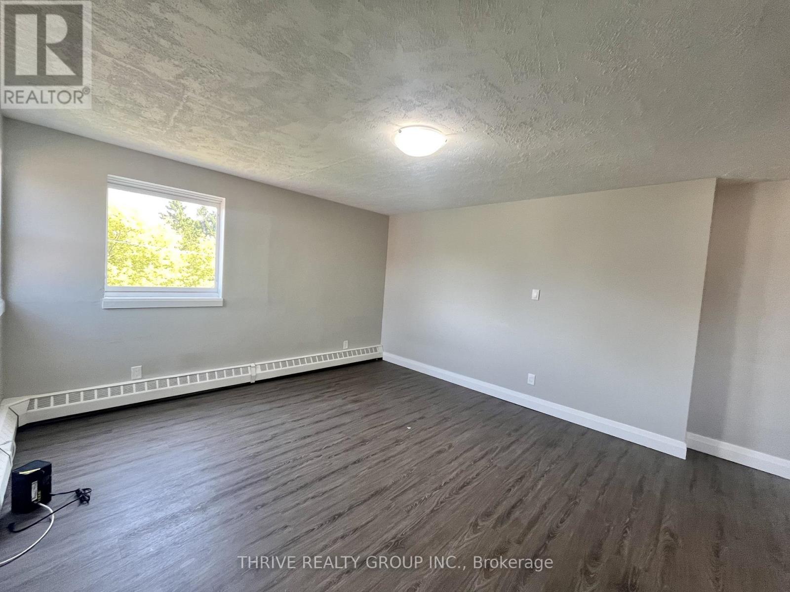 A room with a window and wooden flooring.