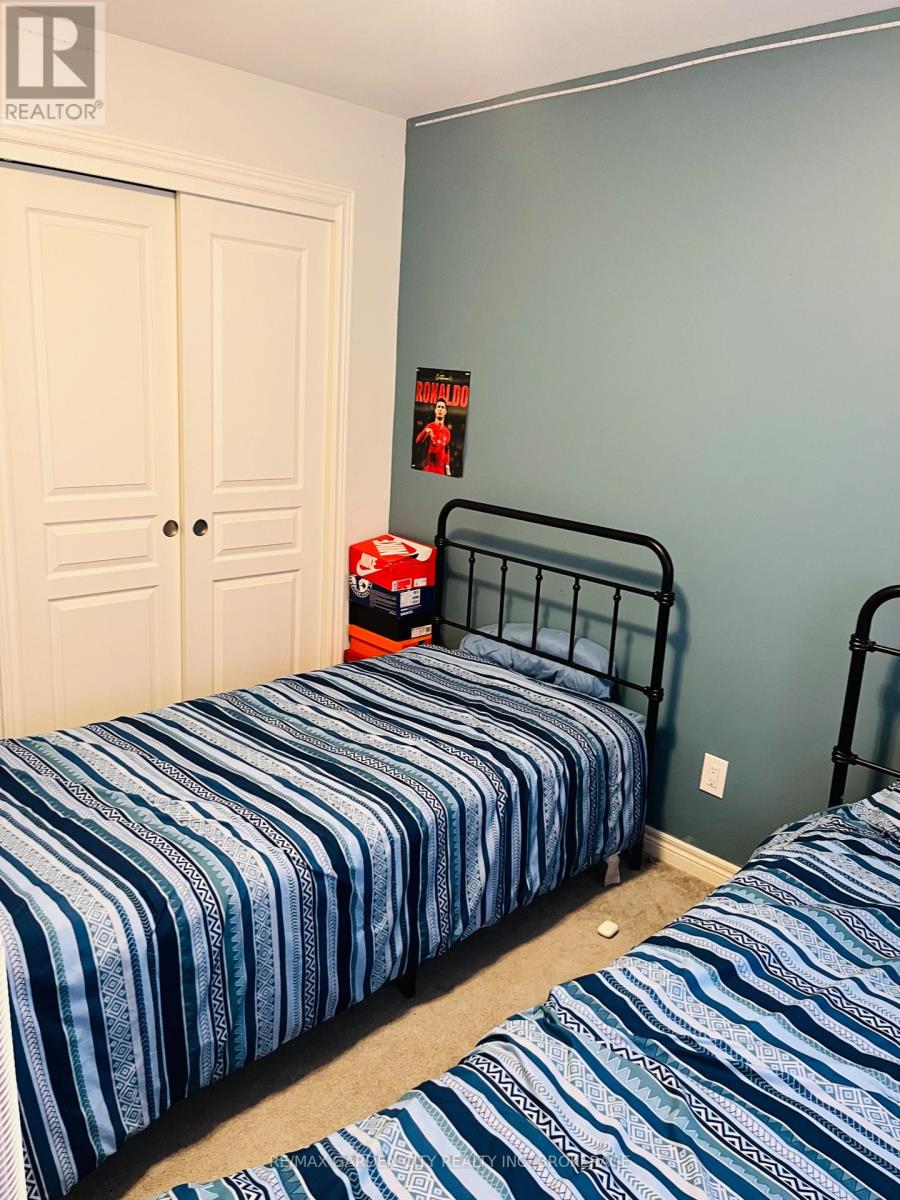 A bedroom with two beds and a white wardrobe.
