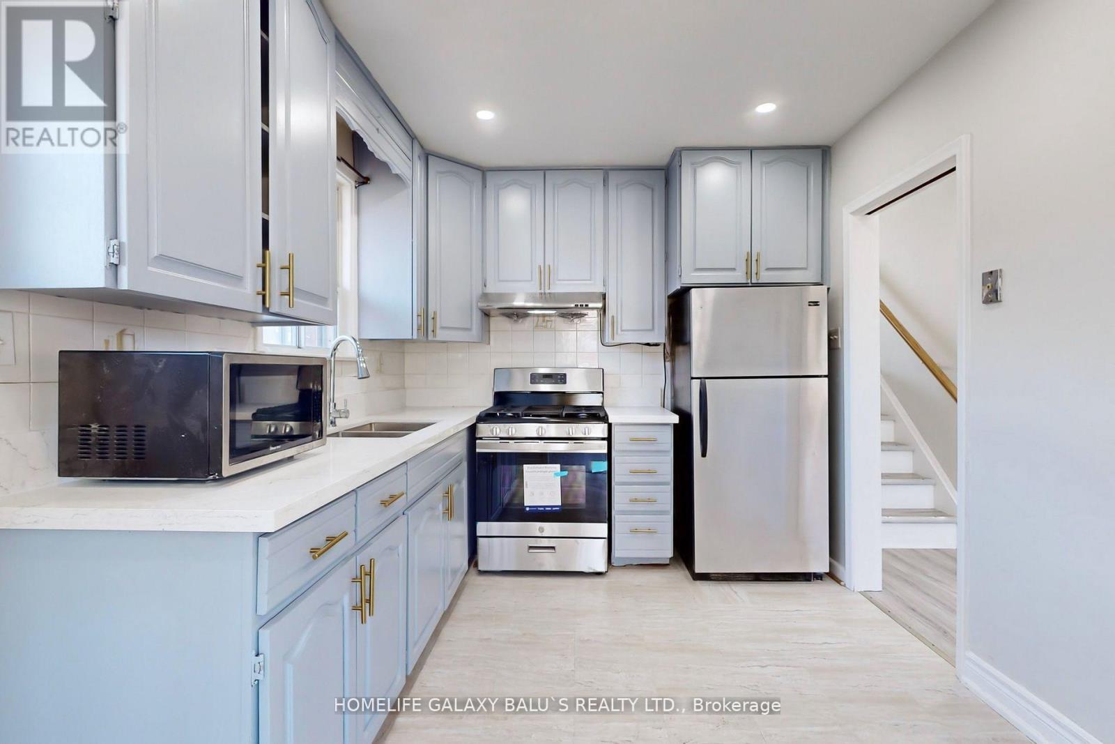 A kitchen with white cabinets and a stainless steel refrigerator.