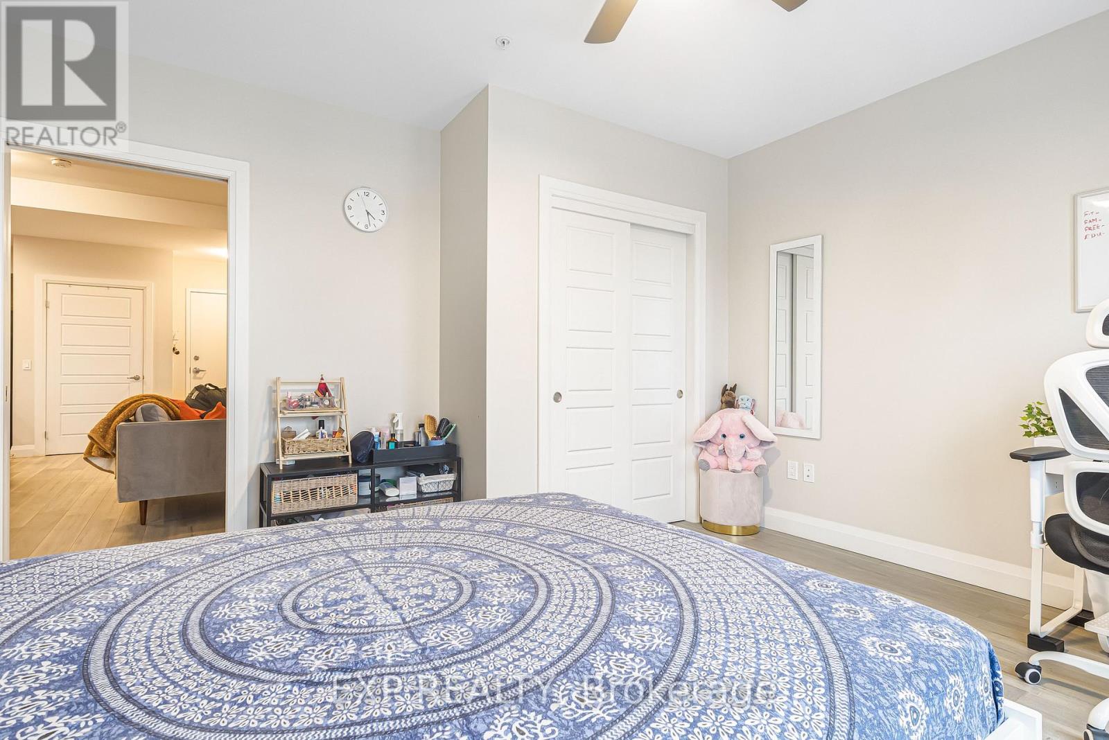 A bedroom with a large bed and a ceiling fan.